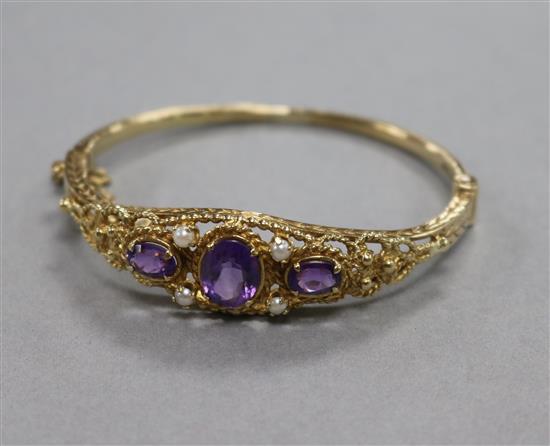 A 1970s Victorian style amethyst and seed pearl hinged bangle,